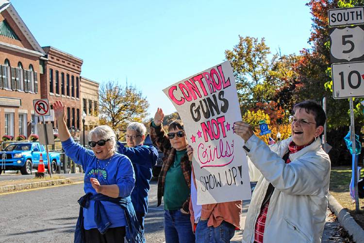 A group of demonstrators gathers along the edge of the Greenfield Common on Saturday as part of a rally in support of the Harris-Walz campaign.
