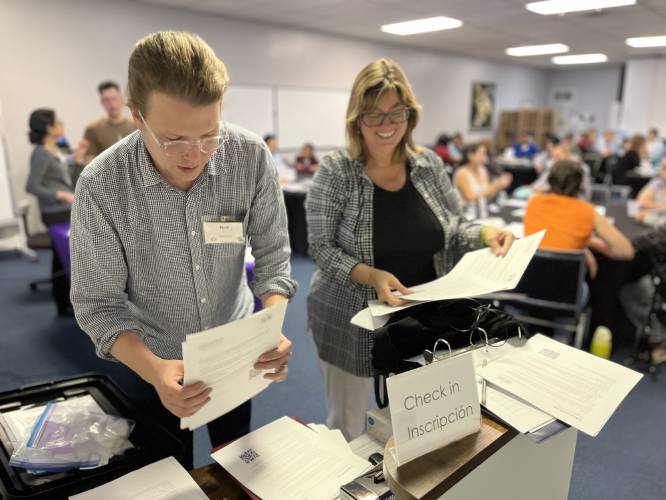From the right, Krista Harper, principal investigator of the Holyoke Community Energy project, and Nick Caverly, anthropology professor, organize papers at a check-in for one of the project’s many community workshops.