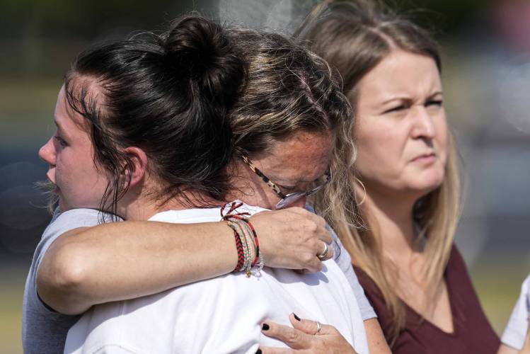 People embrace at a makeshift memorial after a shooting at Apalachee High School in Winder, Ga.