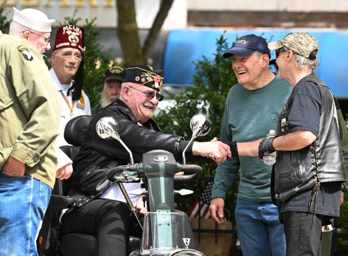 Local veterans greet each other at Veterans Mall in Greenfield before ceremonies on Memorial Day in Greenfield Monday.