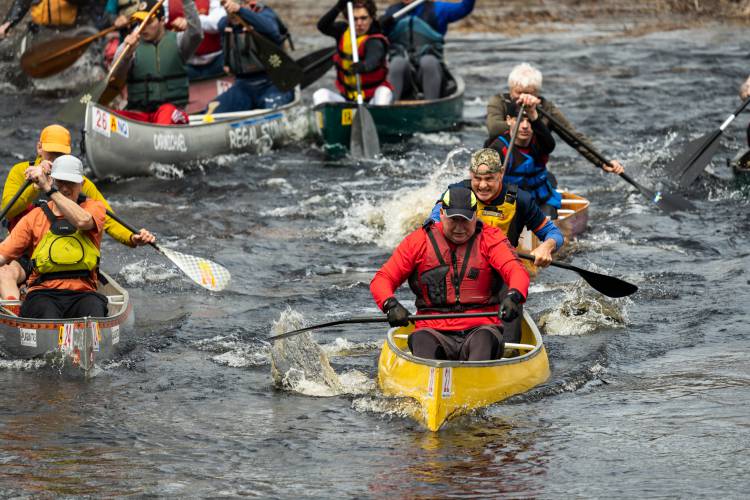 This year’s River Rat  Race saw nearly 180 canoes travel down a 5.2-mile stretch of the Millers River from Athol to Orange. Top: Spectators line the Main Street bridge for the start. Right: Ryan Zaveral and Shane MacDowell cross the finish line first.Below left: Canoers wait for the start. Below right: Thomas and Elliott Payne participate. FOR THE RECORDER/JAMIE MALCOLM-BROWN