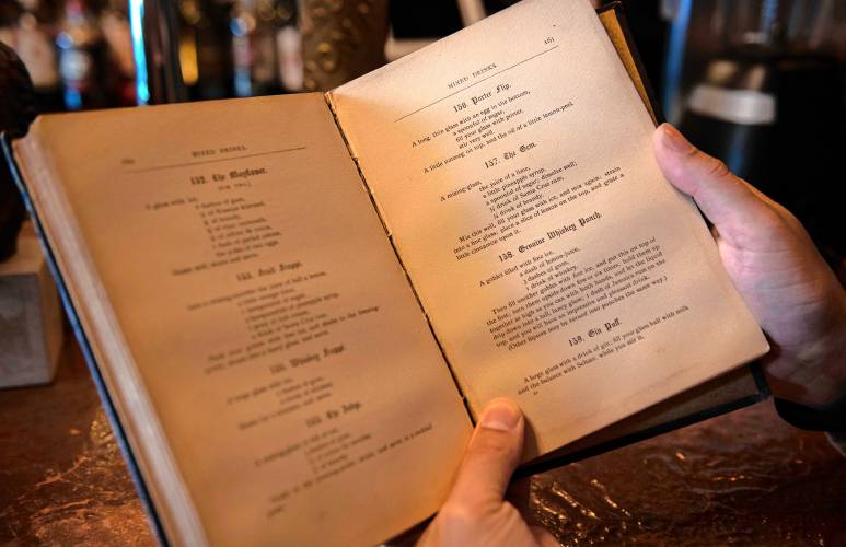 Ned King, bar manager of Gigantic in Easthampton, holds the book where he got the original recipe for a drink called the Gem.