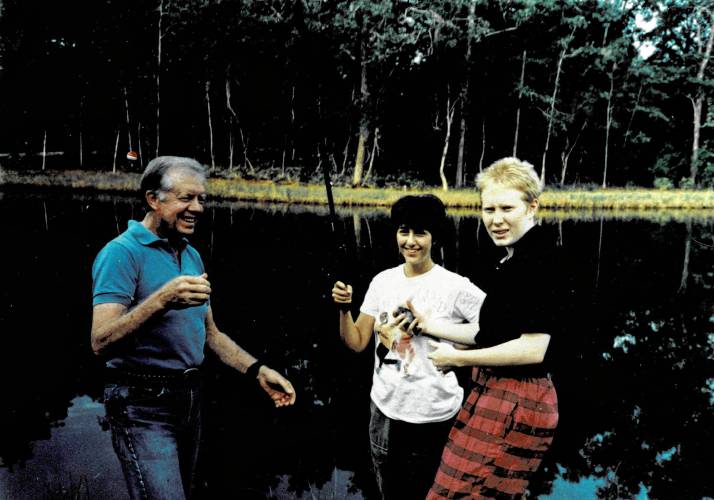 Northampton City Councilor Rachel Maiore catches a fish with former President Jimmy Carter and his daughter, Amy Carter, at their Plains, Georgia property in 1992. 