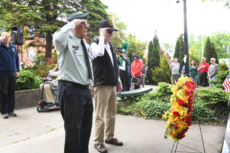 Vietnam-era veterans Bill Phelps and Dennis Dwyer salute after laying a wreath at the Vietnam War Memorial at Veterans Mall in Greenfield during ceremonies on Memorial Day in Greenfield Monday.
