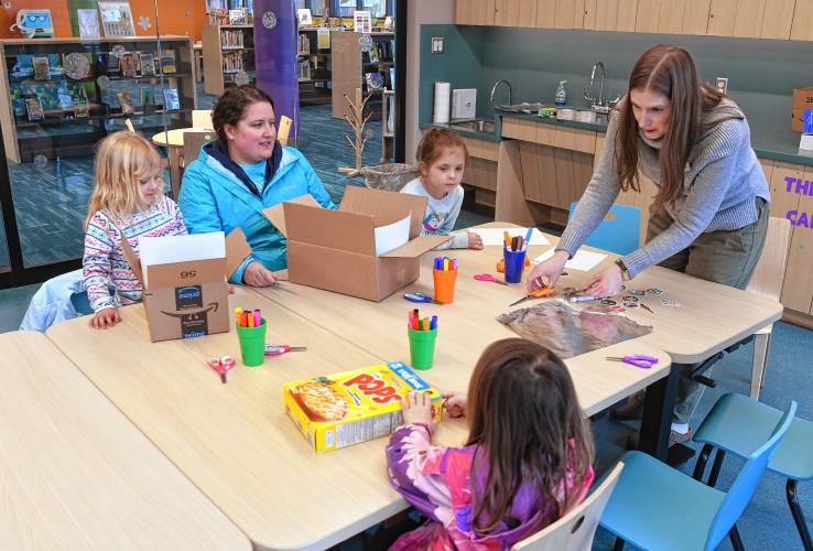 Children’s Librarian Ellen Lavoie helps patrons make eclipse-viewing boxes during a workshop at the Greenfield Public Library on Wednesday.
