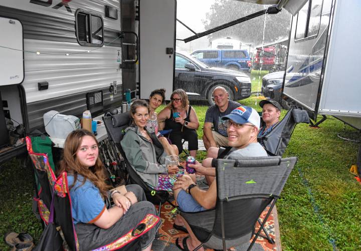 A group from Vermont waits out the rain in the campground area after thunderstorms delayed the start of the Green River Festival on Friday night at the Franklin County Fairgrounds.