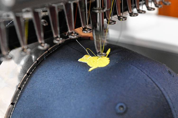 A hat has a logo embroidered on it at Melissa Murphy Embroidery and Custom Apparel in Bernardston.