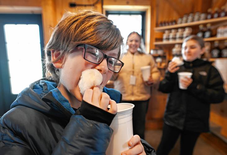 Bernardston Elementary School fifth grader Garrett Liberatore and other students enjoy maple cotton candy while visiting Bald Mountain Sugar House in Bernardston.