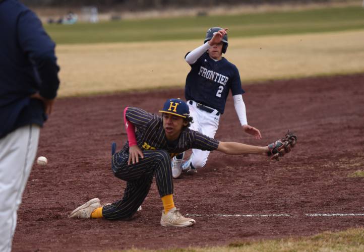 Hopkins Academy’s Nate Rickles, front, can’t stop the throw from the Golden Hawks’ catcher as Frontier’s Carter Miller (2) slides into third before heading toward home on Wednesday afternoon in Hadley.