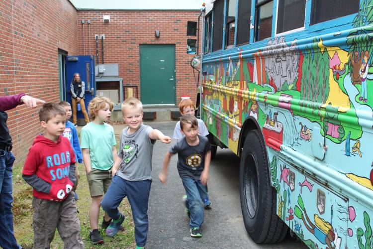 Colrain Central School students play “I Spy” with a mural painted on a school bus that was converted into the mobile home and library of the husband and wife author/illustrator team of Matthew Swanson and Robbi Behr.