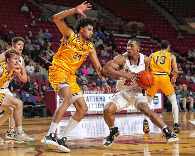 UMass’ Keon Thompson (5) drives to the basket while defended by La Salle’s Tunde Vahlberg Fasasi (34) during Atlantic 10 Conference action at the Mullins Center in Amherst on Wednesday.
