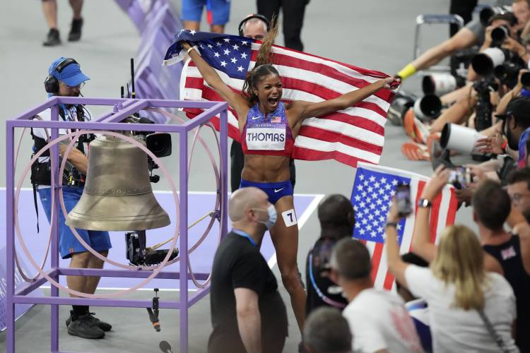 Gold medal winner Gabby Thomas celebrates after ringing a bell, following the women's 200 meters final at the 2024 Summer Olympics, Tuesday in Saint-Denis, France.