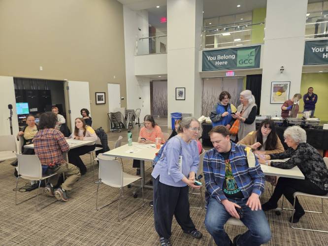 Greenfield Community College students help attendees create accounts on the GivePulse mobile app during Resilient Greenfield’s launch event on Saturday.