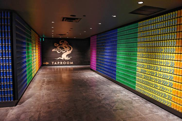 The hallway to the taproom at Tree House Brewing Co. in Deerfield is lined with cans and the company’s history.