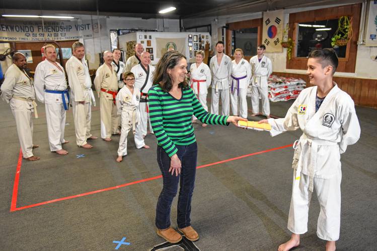 Patti Wasilewski of the Greenfield Recorder accepts a donation from Natan Volosenco, 12, from the Greenfield Tae Kwon Do Center. The Federal Street center holds a “break-athon” fundraiser each year to benefit Warm the Children, the Greenfield Recorder’s charity that helps provide warm clothing for families in need across Franklin County and the North Quabbin region. The 21st annual “break-athon,” held in November, raised $6,308 for the charity.
