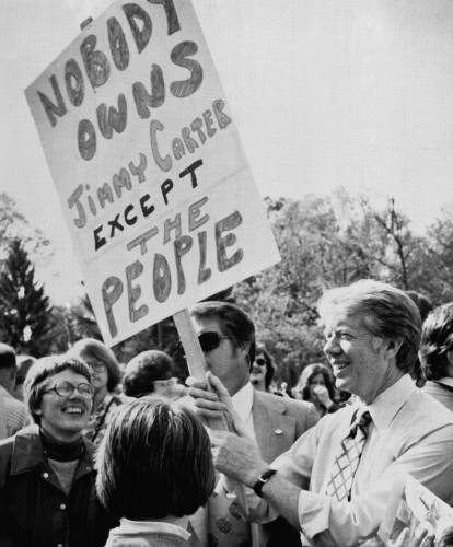 Democratic presidential hopeful, former Georgia Gov. Jimmy Carter, right, holds a poster as he mingles with the crowd during a campaign visit in Williamsport, Pennsylvania, on April 24, 1976.