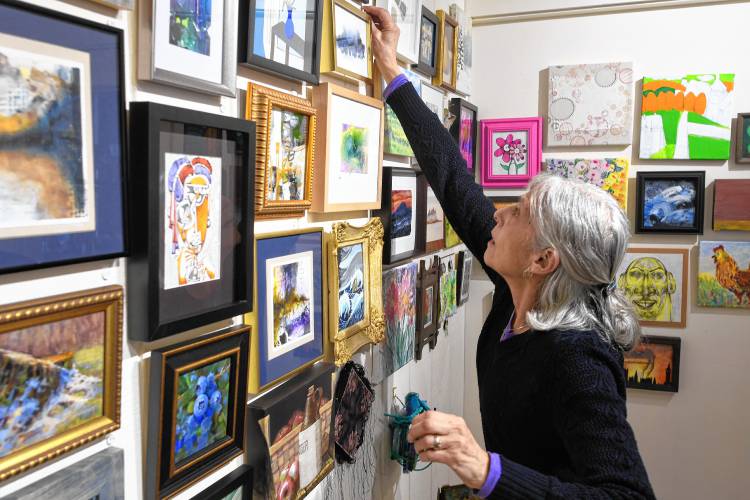 Sawmill River Arts Gallery member Joan Levy labels artwork.