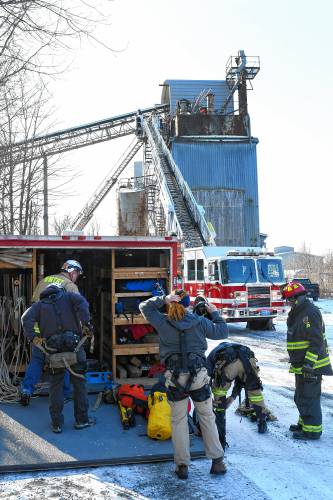 Members of the Western Massachusetts Technical Rescue Team gear up for a rescue attempt of a man trapped in a silo at Chicopee Concrete Service at the end of Cleveland Street behind Sandri Energy on Chapman Street.