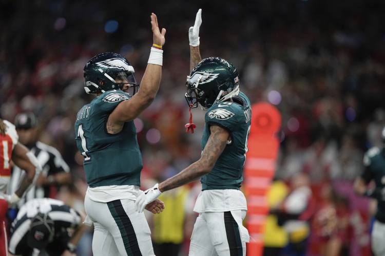 Philadelphia Eagles quarterback Jalen Hurts, left, celebrates with wide receiver DeVonta Smith, right, after a touchdown by wide receiver A.J. Brown during the first half of the NFL Super Bowl 59 football game against the Kansas City Chiefs, Sunday, Feb. 9, 2025, in New Orleans. (AP Photo/Matt Slocum)