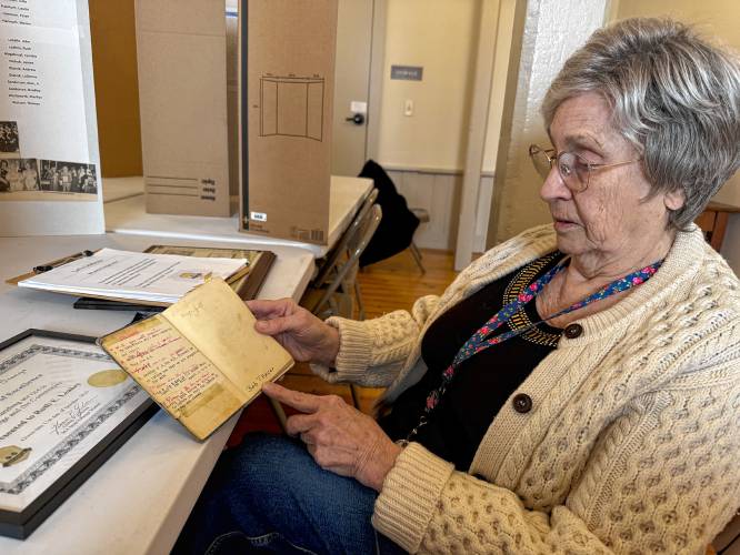 Whately Grange President Ruth Leahey holds the Grange manual her father held when he served as president of the organization in 1961.