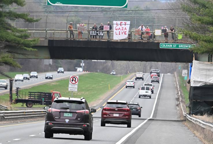 Protesters gather on the Colrain Street overpass of Interstate 91 in Greenfield on Friday afternoon. According to an announcement from Franklin County Continuing the Political Revolution member David Greenberg, the “Overpass Day” aimed to “raise awareness about the multiple attacks on our society and our democracy by the Trump administration.”