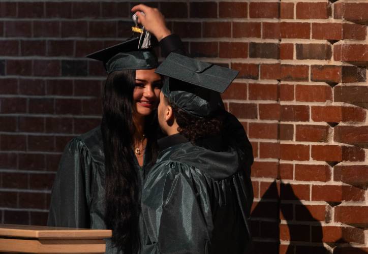 Greenfield High School graduate Miguel Lopez moves the tassel of Brookelynn Lawrence’s cap after they both recieved their diplomas at the Saturday’s graduation.