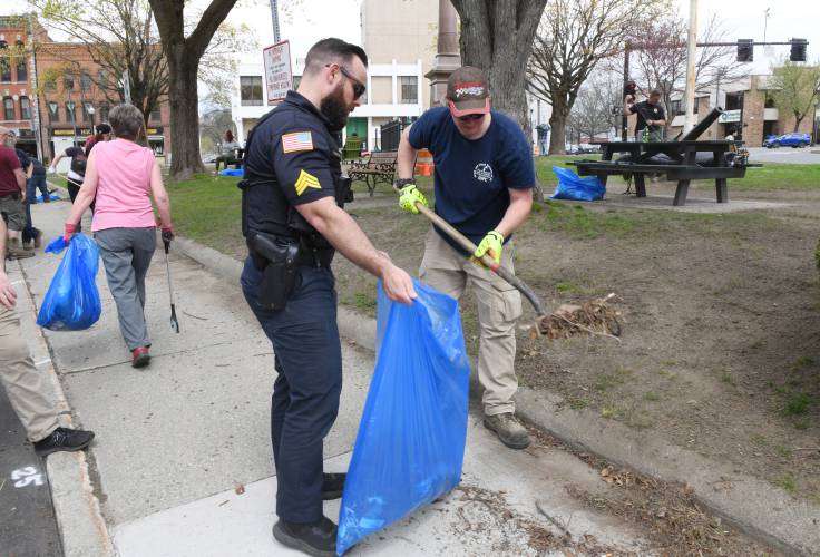 Greenfield Police Sgt. Justin Purinton and Clive Fernet of the city’s Department of Public Works help out.