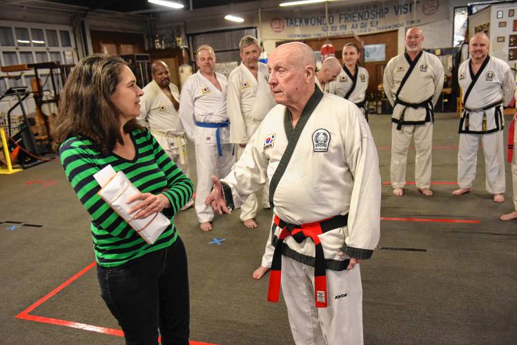 Patti Wasilewski of the Greenfield Recorder talks with Greenfield Tae Kwon Do Center owner and instructor David Johnson. The Federal Street center has raised a total of $115,755.55 to benefit Warm the Children, the Greenfield Recorder’s charity that helps provide warm clothing for families in need, since starting its annual “break-athon” fundraiser 21 years ago.