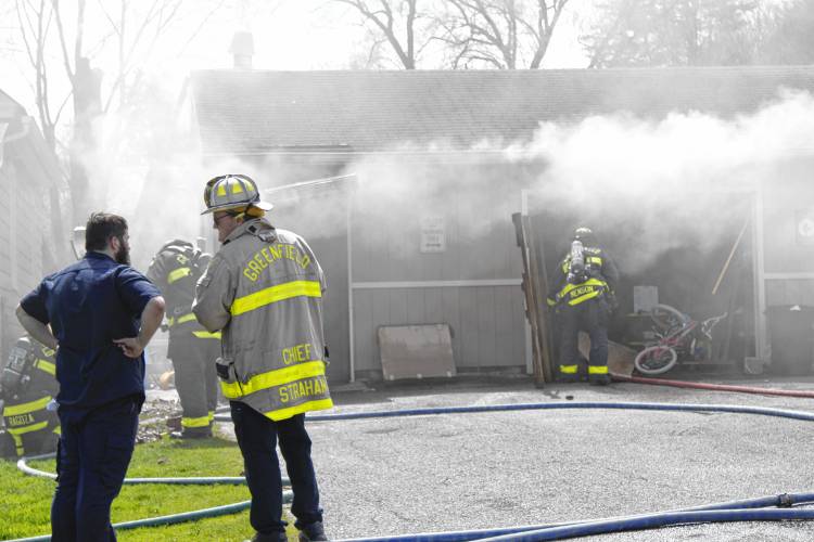 Homeowner Jeff Andrews and Greenfield Fire Chief Robert Strahan stand next to each other as firefighters extinguish a fire at Andrews’ garage on Homestead Avenue on Wednesday afternoon. Homeowner Jeff Andrews and Greenfield Fire Chief Robert Strahan stand next to each other as firefighters extinguish a fire at Andrews’ garage on Homestead Avenue on Wednesday afternoon.