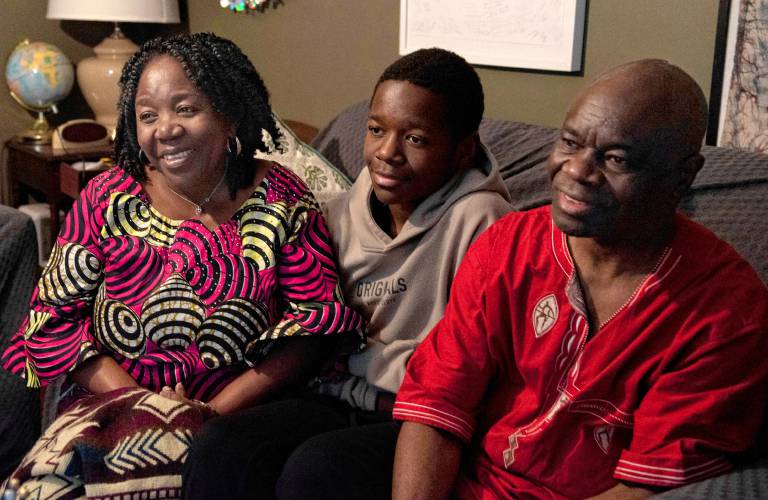 Asani Furaha, left, and Mateso Kagenyekero, right, sit with their son, Divin Mwami Heri at their home in Northampton.