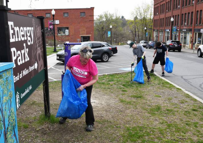 Greenfield Mayor Ginny Desorgher, Economic and Community Development Assistant Christian LaPlante, and Mayor’s Office Communications Director Matt Conway pick up trash at the end of Miles Street in Greenfield as part of a downtown cleanup on Friday.