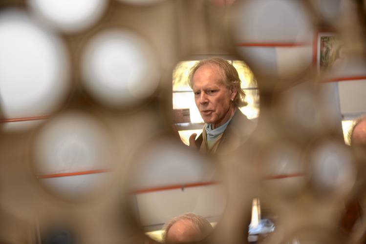 Joseph “JJ” White reflected in an art piece in his studio behind his Greenfield home.