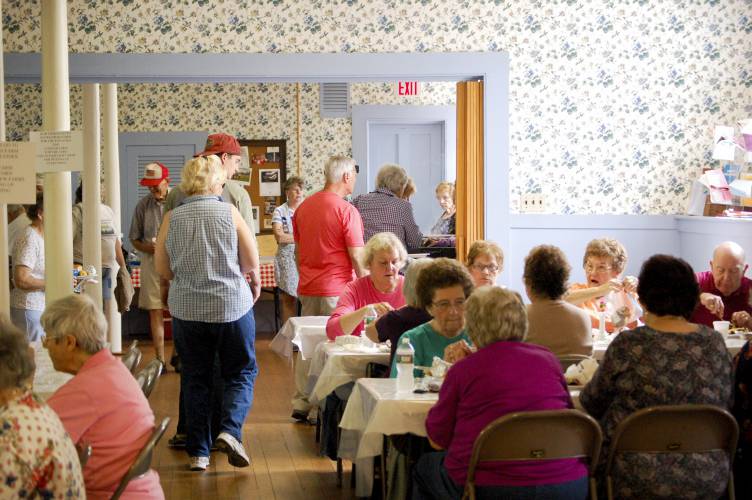 Attendees enjoy the First Congregational Church of Whately’s annual chicken barbecue in 2017. The community tradition, now offered in a to-go format, returns on Labor Day, Sept. 2.