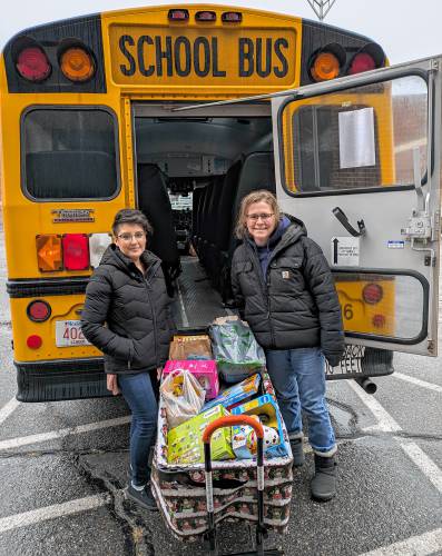 Travel Kuz Transportation Coordinator Brittany Earl, left, and Administrative Assistant Michelle Howe with a basket of donations as part of this year’s “Busloads of Blessings” donation drive.