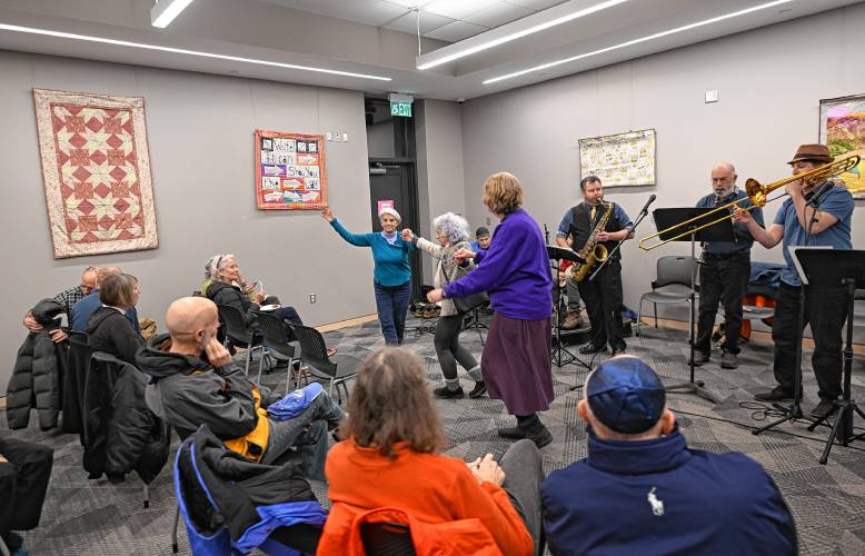 People dance to the JCA Klezmer Ensemble at a Hanukkah potato pancake social at the Greenfield Public Library on Monday evening.