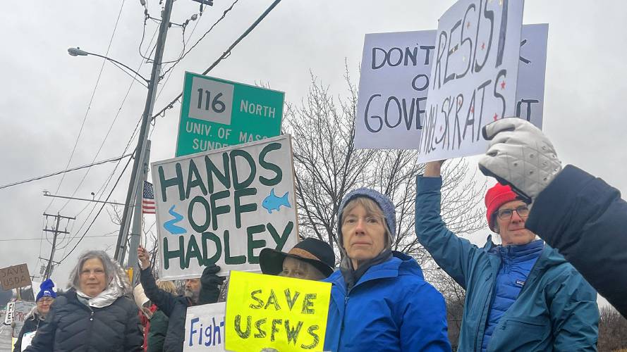 From right, Peter Marvin, Mary McKitrick and Jennifer Kramer stand on the sidewalk of Route 9 in Hadley on Monday to protest the firing of the 36 probationary U.S. Fish & Wildlife Service workers.