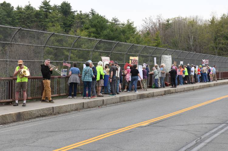 Protesters gather on the Leyden Road overpass of Interstate 91 in Greenfield on Friday afternoon. According to an announcement from Franklin County Continuing the Political Revolution member David Greenberg, the “Overpass Day” aimed to “raise awareness about the multiple attacks on our society and our democracy by the Trump administration.”