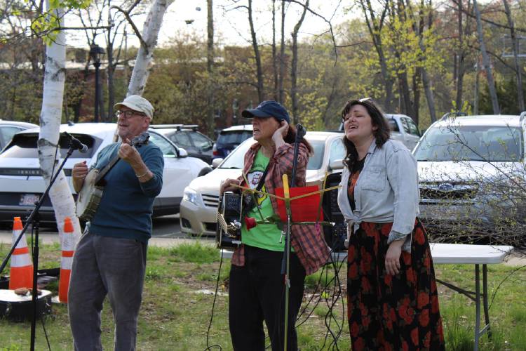 From left, Court Dorsey, Annie Hassett and Lucy Bergen sing labor songs in Turners Falls on Thursday for the “International Labor Day Bread and Roses Parade and Rally.”