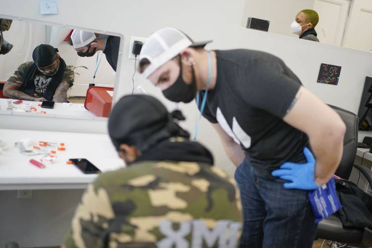 Brian Hackel, right, an overdose prevention specialist, helps Steven Baez, a client suffering from addiction, find a vein to inject intravenous drugs at an overdose prevention center, OnPoint NYC, in New York in 2022. Brian Hackel, right, an overdose prevention specialist, helps Steven Baez, a client suffering from addiction, find a vein to inject intravenous drugs at an overdose prevention center, OnPoint NYC, in New York in 2022.