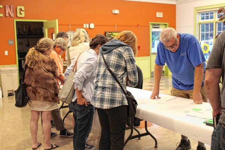 Residents examine paper copies of the proposed Route 2 redesigns at the Erving Senior & Community Center on Wednesday.
