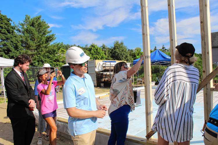 Volunteers sign the beams on the first wall of Pioneer Valley Habitat for Humanity’s 184 Petty Plain Road affordable house in Greenfield.