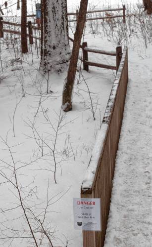 A sign on the path that leads to a cleared spot for skating on Puffer’s Pond warns people about the dangers of skating on the pond, and reminds them that they are skating at their own risk. 