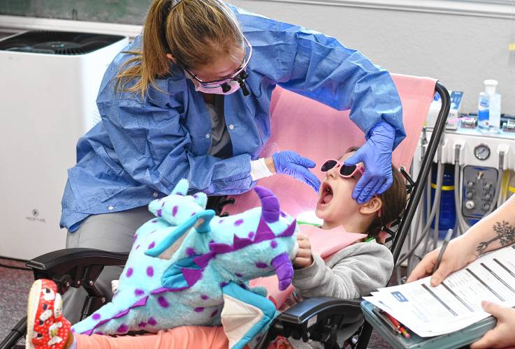 Dental hygienist Jennifer Hauschild checks out the teeth of Paisley Crafts, screening for problems and doing fluoride treatments at the Head Start program in Turners Falls on Wednesday morning.