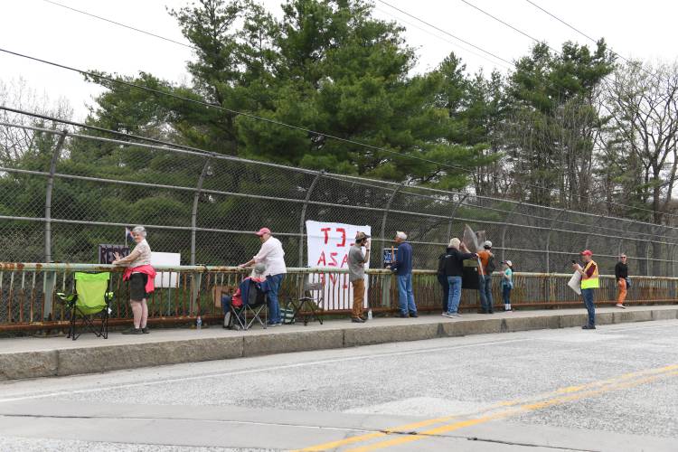 Protesters gather on the Colrain Street overpass of Interstate 91 in Greenfield on Friday afternoon. According to an announcement from Franklin County Continuing the Political Revolution member David Greenberg, the “Overpass Day” aimed to “raise awareness about the multiple attacks on our society and our democracy by the Trump administration.”