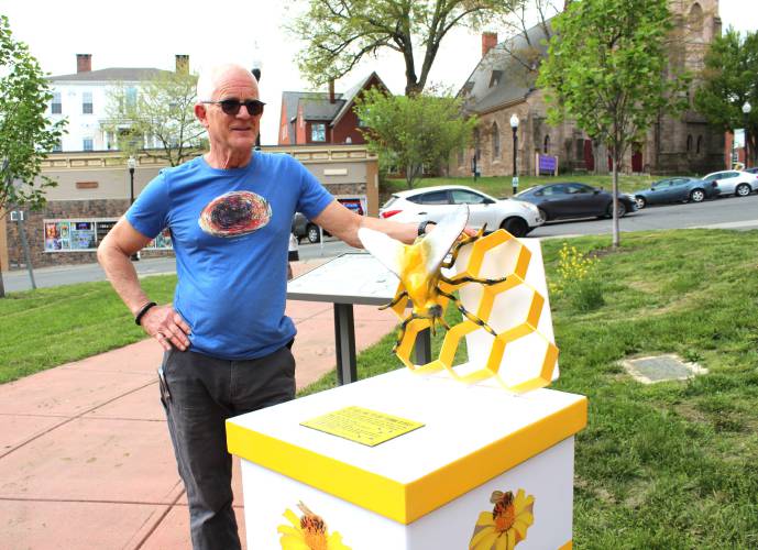 Artist Thor Holbek stands in front of the beehive sculpture on Bank Row in Greenfield that he restored after it was vandalized.