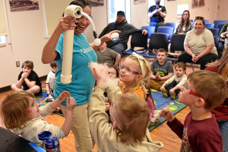 Amaris Montoya of Talewise blows soap bubbles full of sublimating dry ice over volunteers during a Science Heroes program at the Athol Public Library earlier this month.