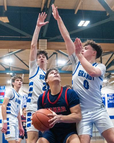 Mahar's Jayden Delgado, center, looks to attempt a layup past Granby's Gavin Moreno, left, and Sawyer Clarke, right, during the PVIAC Class C tournament semifinal game at Granby High School, Tuesday, Feb. 18, 2025, in Granby.