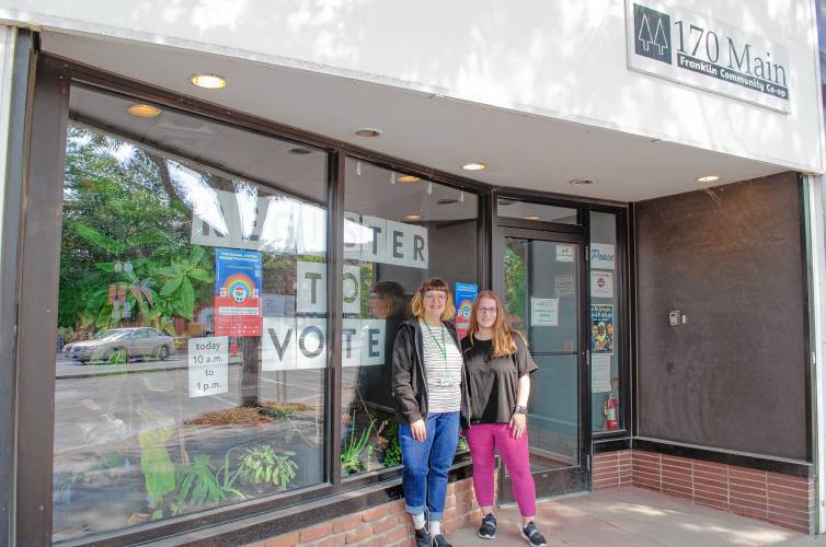Franklin Community Co-op Outreach and Communications Manager Caitlin von Schmidt and Graphic Designer Jenna Robinson outside the co-op’s community space in downtown Greenfield, where they were offering support with voter registration on Tuesday.