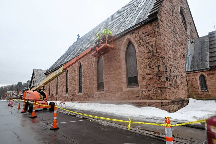 Workers access the damage to the roof of the Episcopal Church of Saints James and Andrew in Greenfield on Wednesday that sustained damage amid high winds.