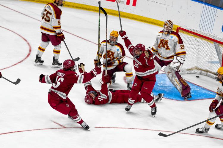 UMass players celebrate one of the team’s goals during its 5-4 overtime win over Minnesota on Thursday night. 